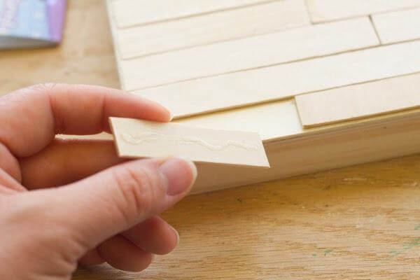 Dán so le các que kem lên tấm gỗ hình vuông (Nguồn: Internet)