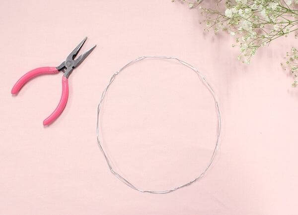 Vặn xoắn sợi kẽm để tạo hình cho vòng hoa đội đầu (Nguồn: Internet)