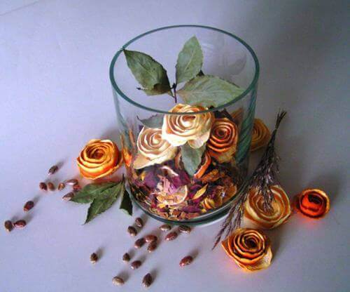 Đặt những bông hoa vỏ cam sau khi đã hong khô vào lọ thuỷ tinh và thêm vào đó một số cánh hoa khô ướp hương bạn đã chuẩn bị (Nguồn: Internet)